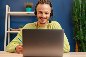 Young man with headset looking at laptop camera. Service consultant concept