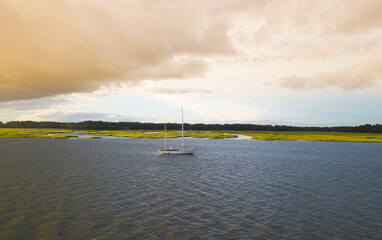 Wall Mural - Aerial view of sailboat moored off the coast of South Carolina at sunset.