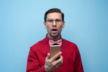 Wall Mural - Portrait of a shocked young man with smartphone