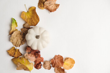 Sticker - Top view of pumpkin decoration with autumn leaves isolated on white background for holiday season.