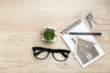 Wall Mural - House model with glasses, green plant and silver keys on wooden table