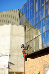 Two window cleaners working in an office building. Vertical risk work