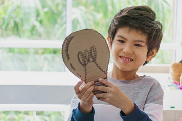 Cute little kid boy holding paper light bulb. Energy, Power, Idea, Inspiration, creative, kid, children, smart concept. Copy Space.