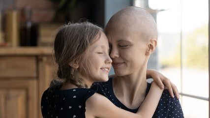 happy young caucasian cancer patient sick mother and little daughter hug show love and care, support