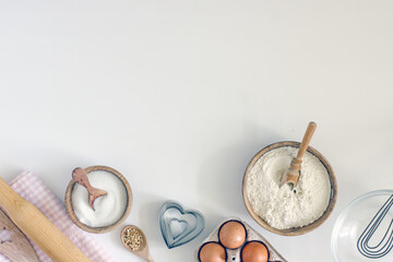 Ingredients for home baking cookies butter, sugar, eggs, flour, cookie cutters, rolling pin on a light background, top view. DIY homemade cookies background