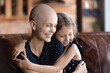 © fizkes - Cute little girl hug cuddle sick cancer patient hairless mom show love and support, happy grateful small daughter embrace caress ill bald young mother, suffer from health problems, healthcare concept
