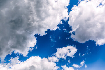 White clouds against a bright blue sky. Change from clear sunny weather to cloudy. Wallpaper for news about weather forecast. Clearing after rain. Religious appeal to the Almighty. Infinity feel.