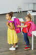 © ShunTerra - a girl kid student is interested in a new beautiful backpack of a classmate
