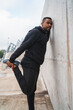 © Mego-studio - Athletic man stretching legs before exercise.