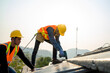© visoot - Construction worker wearing safety harness belt during working on roof structure of building on new roof.