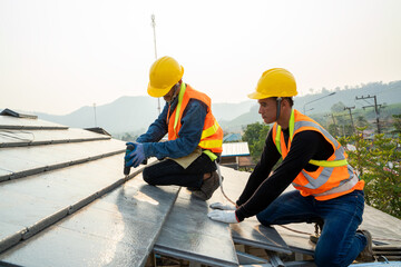 Aufkleber - Professional technician roof install new roof on the roof top,Roofing tools,Hold the drive screw tool in hand.