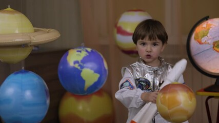 Wall Mural - Space Travel Game Inspiration Spaceship. Little Kid Boy Astronaut Launching Toy Rocket From Spaceport Through Planets. Child Dreamer Playing With Toy Space Rocket Flying Among Planets. SLOW MOTION.