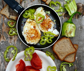 Wall Mural - A simple breakfast on the mountain. Traditional healthy easy quick breakfast meal made of two fried eggs served on a frying pan. International simple food, top view.