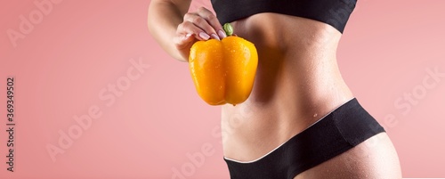 Fotomural Beautiful fitness girl holding a fresh vegetable