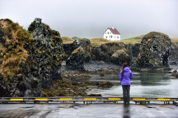 Wall Mural - Iceland nature landscape on Arnarstapi Snaefellsnes. Travel photo of woman tourist looking at view of dramatic coast and ocean on West Iceland. From Arnarstapi harbour, Iceland.