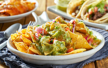 Plate Of Nachos With Guacamole And Salsa