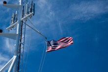 United States Of America Flag Blowing In The Wind On The The Deck Of A Large Ship At Sea