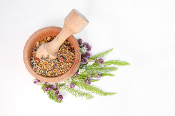 Mortar with fresh herbs isolated on white background