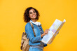 © Atstock Productions - Young amazed African American woman tourist backpacker holding world map on yellow studio background