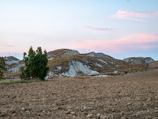 Wall Mural - dry fields clay hills called Sciolle at sunset in the province of Crotone, Calabria, Italy.