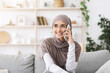 © Prostock-studio - Long-Awaited Call. Happy Muslim Girl In Hijab Having Phone Conversation At Home