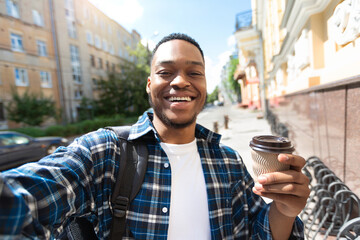 Wall Mural - Excited african american guy taking selfie with coffee