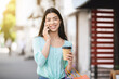 © Prostock-studio - Asian Girl Walking Outdoors With Coffee And Shopping Bags, Talking On Cellphone