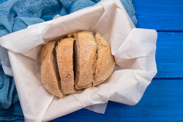 Wall Mural - bread in basket on blue wooden background