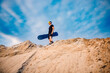 Man sand boarder standing on top with snowboard before extreme downhill