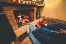Legs View Of Happy Family Lying Down Next Fireplace Wearing Warm Wool Socks - Winter, Holiday, Christmas, Love And Cozy Concept - Focus On Closeup Feet