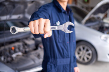 The mechanic is carrying the tools in the garage and is ready to provide service.