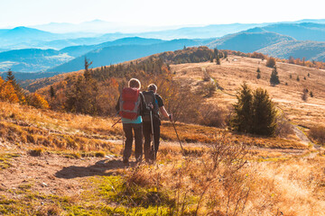 active recreation and hiking of two old people in the autumn mountains