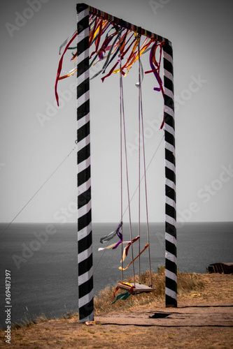 Fotografía large swing with colored ribbons on the cliff