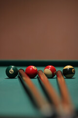 Poster - Vertical shot of colorful billiard balls and cue sticks on billiard table