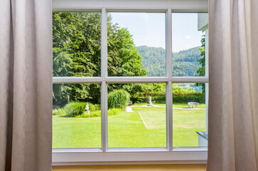 view of the window in the room on a green park on a sunny summer day