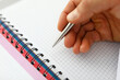 © Тихон Купревич - Man's hand holds pen on blank notebook. Stationery and training concept