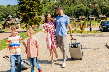Wall Mural - smiling family of four going to the hotel to check in at the reception for vacation.