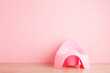 Baby potty on floor at wall. Front view. Closeup. Empty place for text on light pink background. Pastel color.