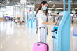 © tonefotografia - A traveller woman is wearing protective mask in International airport, travel under Covid-19 pandemic, safety travels, social distancing protocol, New normal travel concept