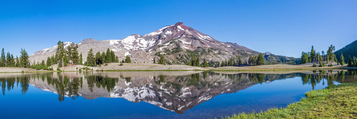 Wall Mural - mountain landscape with clear blue sky, morning light, reflective water, and a wide panoramic view.