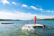 © Sarah Rypma - Young girl in pink bathing suit jumping off of raft into lake