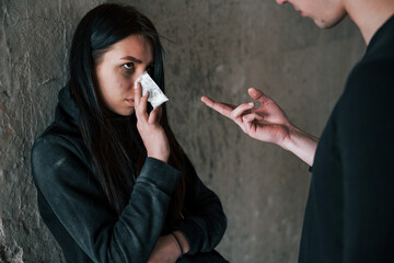 Two people standing with illegal drugs in little package indoors