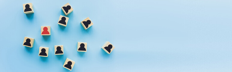 Wall Mural - top view of wooden blocks with black and red human icons scattered on blue background, leadership concept, panoramic shot