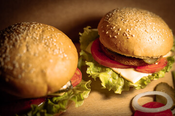 Wall Mural - Two delicious cheeseburgers with tomatoes, cucumbers and lettuce. Fresh tasty burgers