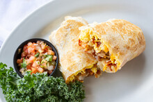 A Top Down View Of A Breakfast Burrito, In A Restaurant Or Kitchen Setting.