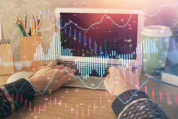 Double exposure of woman hands typing on computer and forex chart hologram drawing. Stock market invest concept.