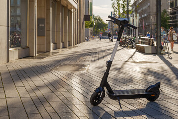 Wall Mural - Selected focus at E-scooter or Electric Scooter by startup company with concept of Eco friendly mobility urban lifestyle, park at Schadowplatz in Düsseldorf, Germany.