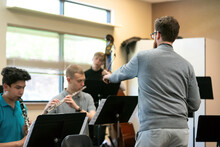 Teacher Instructing Students In Music Class
