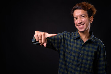 Wall Mural - Portrait of happy young Asian hipster man with curly hair