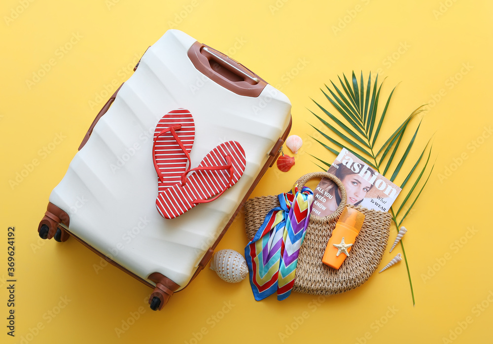 Packed suitcase with beach accessories on color background. Travel concept